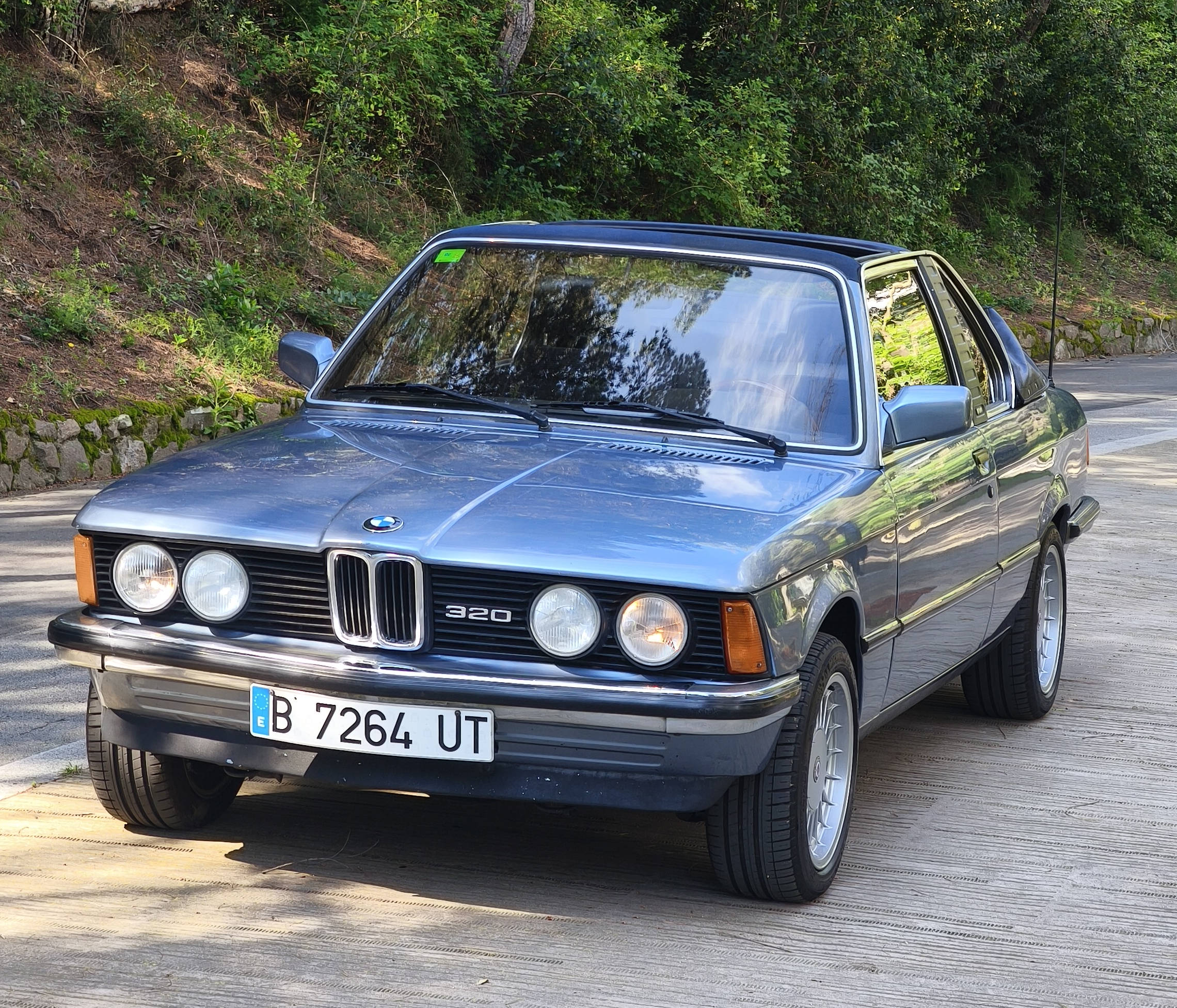 BMW E21 on a forested road — period-feature shoot location