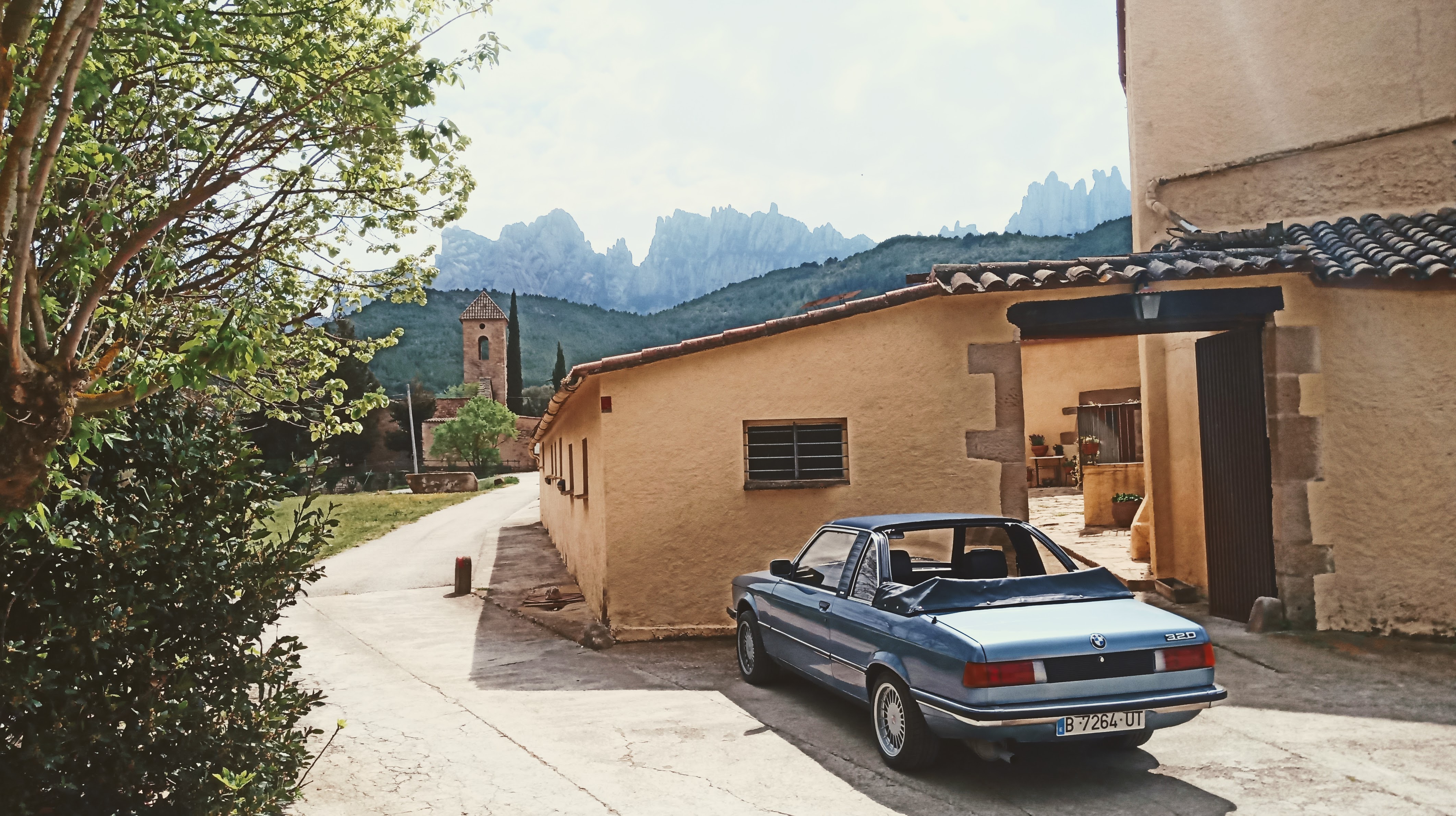 Rear three-quarter view of the BMW E21 with Montserrat in the background, top down